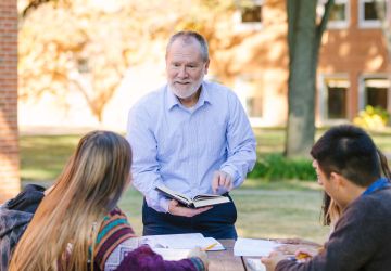 Bible faculty outdoors with students
