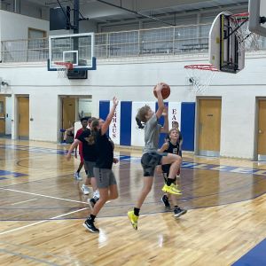 Middle school boy makes a basketball layup