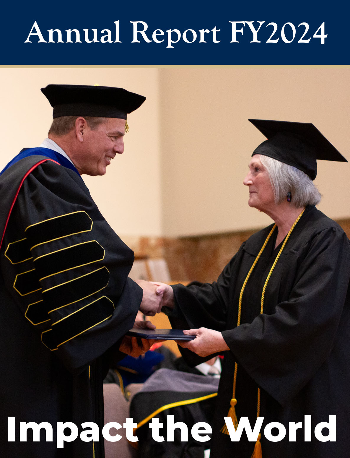 Man in graduation cap and gown shaking hands and giving degree to woman in cap and gown