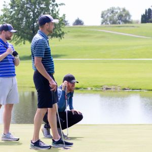 Two standing golfers and one crouching