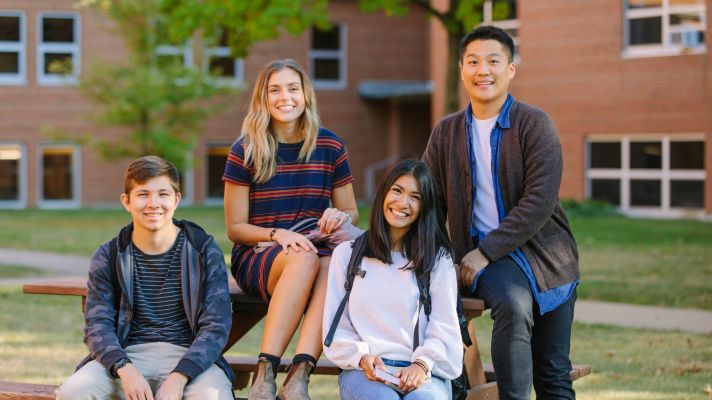 students sitting together on a picnic table